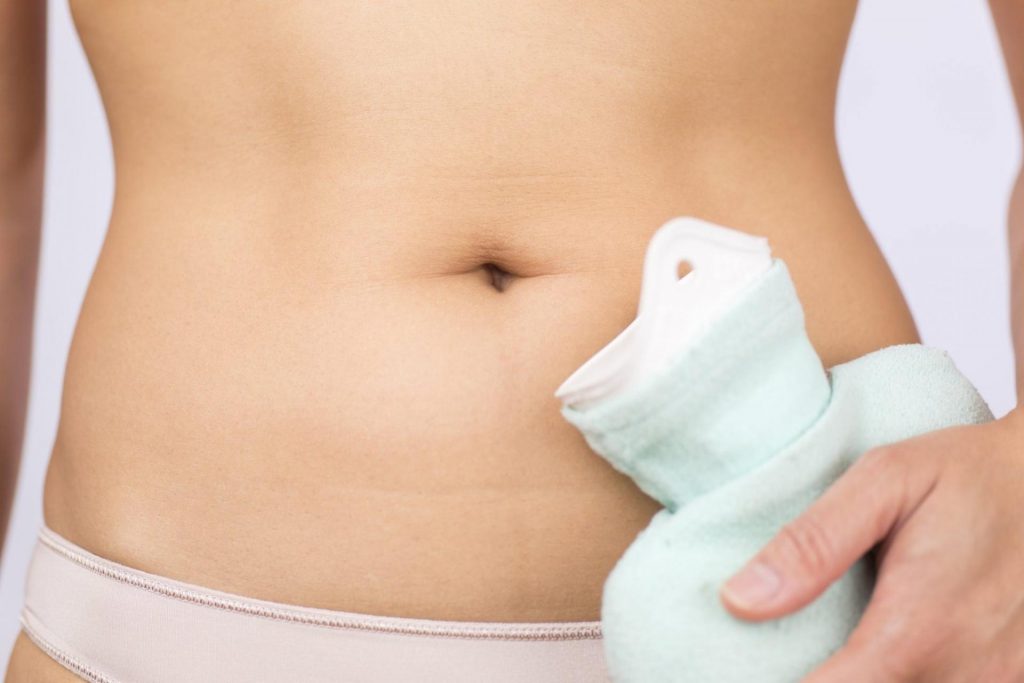 Girl with a heating pad at the lower abdomen, cystitis